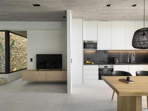 eine Küche mit weißen Schränken und einem Esstisch in der Unterkunft Design Villa Nea Skioni by Halkidiki Villas in Nea Skioni