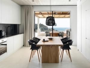 eine Küche und ein Esszimmer mit Tisch und Stühlen in der Unterkunft Design Villa Nea Skioni by Halkidiki Villas in Nea Skioni