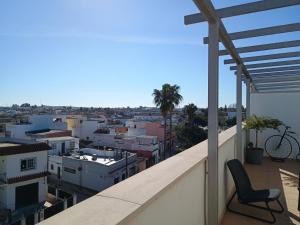 a chair on a balcony with a view of a city at Balcon Mirador De Las Salinas in Sanlúcar de Barrameda