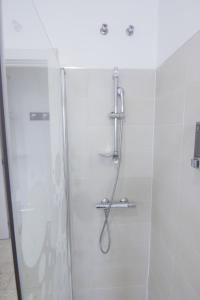 łazienka z prysznicem i szklanymi drzwiami w obiekcie RentalSevilla Plaza del Zurraque w Sewilli