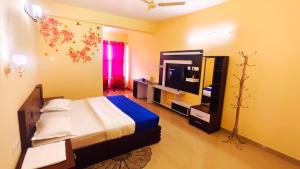 a bedroom with a bed and a television in it at DevaDheyam Homestay in Munnar