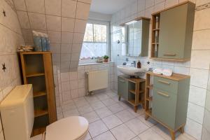 a bathroom with a sink and a toilet at Ferienhaus Seesucht in Krummhörn +16 photos