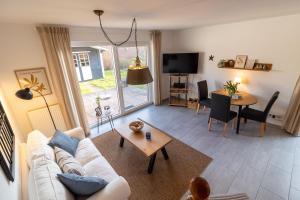 a living room with a white couch and a table at Ferienhaus Seesucht in Krummhörn