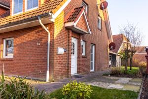 a red brick house with a white door at Ferienhaus Seesucht in Krummhörn
