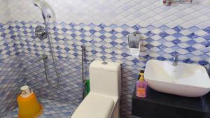 a bathroom with a sink and a toilet and a shower at DevaDheyam Homestay in Munnar