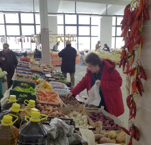 a woman standing in a grocery store selling produce at Casa in Piazza in Vasto