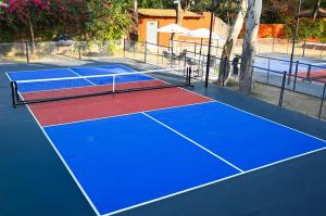 a tennis court with blue and red at Brij Nest, Jaipur - An All Suite Boutique Hotel in Jaipur