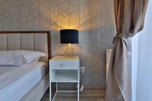 una camera con letto e comodino con lampada di Ada Homes B4628 a Braşov