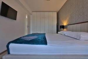 una camera da letto con un grande letto bianco e una televisione di Ada Homes B4628 a Braşov