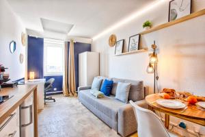 a living room with a couch and a table at Le Tilleul - Centre ville - Parking privé - Wifi in Caen +5 photos