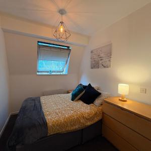 a bedroom with a bed and a dresser and a window at Central One-Bedroom Flat - Free Private Parking in Chesterton