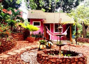 una casa rosa con una fuente frente a ella en Mirante de Lençóis, en Lençóis