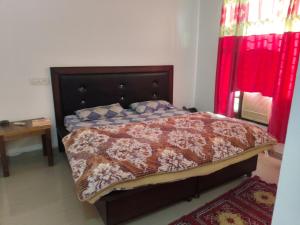 a bedroom with a bed with a red curtain at Hotal Red Flag in Morni