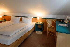 a hotel room with a bed and a table and a chair at Winzerhaus Johannisberg - Weingut Michael Gietz in Geisenheim