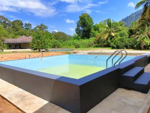 a swimming pool in a resort with a swimming poolvisorvisor at Nok D'Jelutong Homestay Sik Kedah in Sik +4 photos