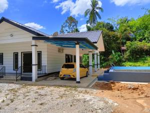 a house with a car parked in front of it at Nok D'Jelutong Homestay Sik Kedah in Sik