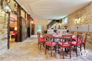 a dining room with a table and red chairs at Domaine de lafayette - sejours bien-etre et detente in Saint-Marcel
