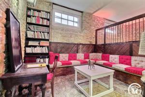 a living room with a red couch and a piano at Domaine de lafayette - sejours bien-etre et detente in Saint-Marcel