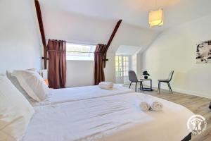 a bedroom with a large white bed with towels on it at Domaine de lafayette - sejours bien-etre et detente in Saint-Marcel +41 photos