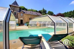 a swimming pool with two chairs and a greenhouse at Domaine de lafayette - sejours bien-etre et detente in Saint-Marcel