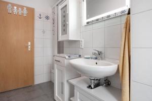 a white bathroom with a sink and a toilet at Meer-Natur-Idyll in Peenemünde +19 photos