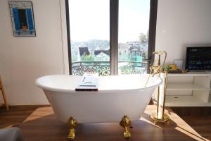 a white bath tub sitting in front of a window at Love Hotel - Khách Sạn Theo Giờ in Da Lat +161 photos