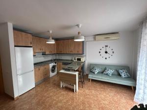 cocina con sofá y reloj en la pared en Apartamento, en Carboneras