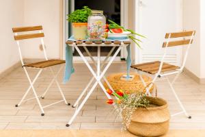 a table with two chairs and a table with plants on it at Opuntia Home in Monopoli