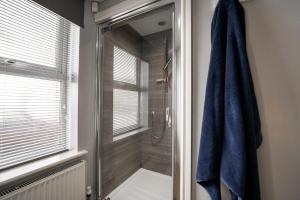 a bathroom with a shower with a blue towel at Luxury 1bed - Contractors Welcome - Fast WiFi in Cleethorpes