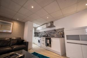 a living room with a couch and a kitchen at Luxury 1bed - Contractors Welcome - Fast WiFi in Cleethorpes +8 photos