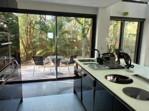 una cucina con vista su un patio di Arcachon-Moulleau Belle villa avec piscine et jardin privés a La Teste-de-Buch