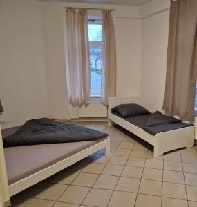 2 Betten in einem Zimmer mit Fenster in der Unterkunft Monteurwohnung für 4 Personen inkl. MwSt. - EG Wohnung in Brunsbüttel