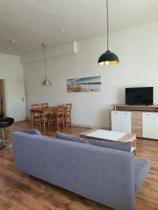 ein Wohnzimmer mit Sofa und Tisch in der Unterkunft Monteurwohnung für 4 Personen inkl. MwSt. - EG Wohnung in Brunsbüttel