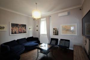 Una sala de estar con un sofá azul y una mesa. en Villa Light, en Certaldo