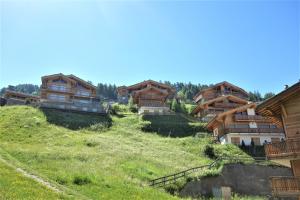 eine Gruppe von Holzhäusern auf einem Hügel in der Unterkunft Les Mayens MB 001 - LUXURY apartment 8 pers in Veysonnaz