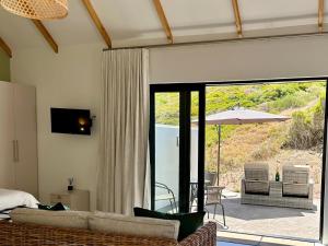a living room with a couch and a patio at The Cottage at Paradise Found in Yzerfontein