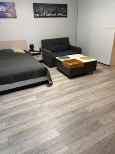 a bedroom with a bed and a couch and wooden floors at Lovely condo in the heart of Warsaw Piękne mieszkanie w samym sercu Warszawy in Warsaw