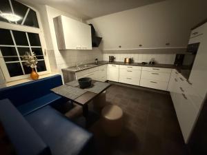 a kitchen with white cabinets and a table in it at Stilvolles Apartment mit Dachterrasse in Garbsen