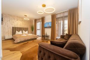 ブラショヴにあるGolden Luxury Apartmentのベッドとソファのある寝室