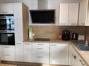 a kitchen with white cabinets and a microwave at Urlaub bei Schönwetter in Raumberg +6 photos