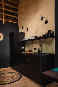 a kitchen with a black counter and a sink at Domek SzumiSosna1 in Raków