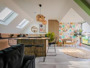 a kitchen and living room with a counter and chairs at Enigma Apartments in Market Harborough