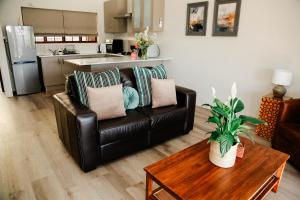 un salon avec un canapé en cuir et une table dans l'établissement MontMartre Chalets & Venue, à Franschhoek