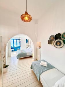 a bedroom with two beds and a chandelier at Kyma Apartments-Little Venice,Mykonos in Mikonos