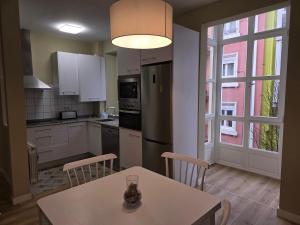 eine Küche mit einem Tisch und eine Küche mit einem Fenster in der Unterkunft Apartamento Centrico RH Santander - Sol 4 in Santander