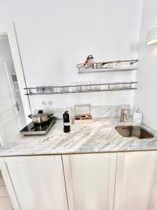 a white kitchen with a counter top with a sink at Kyma Apartments-Little Venice,Mykonos in Mikonos +75 photos