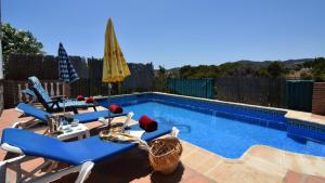 basen z leżakami i parasolem w obiekcie Villa La Lomilla w mieście Nerja
