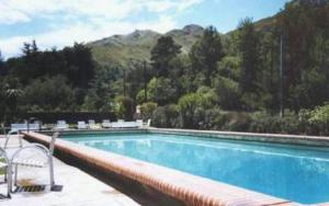 a swimming pool with chairs and a mountain in the background at Hotel Zapata in La Cumbre