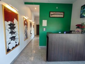 Kandogalbageecha inn的一个带绿色墙壁的大堂和一个前台