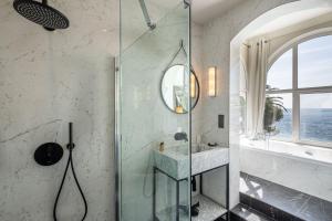 a bathroom with a shower with a sink and a window at La Villa Mauresque in Saint-Raphaël